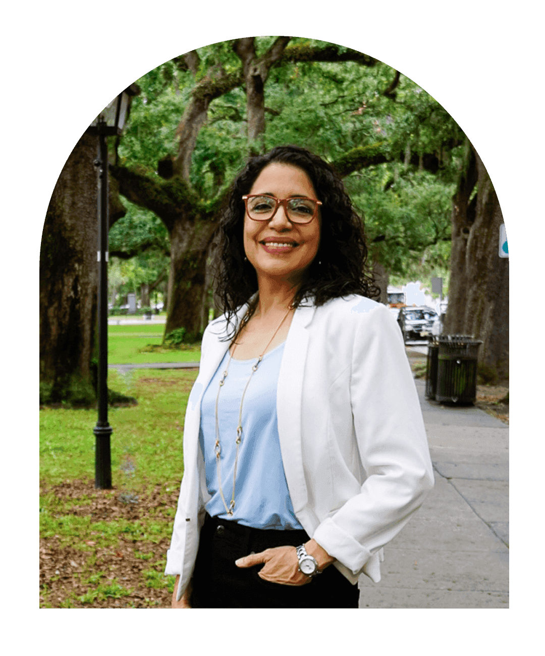 A picture of Dr. Caudill smiling, wearing her physician's coat, and red glasses